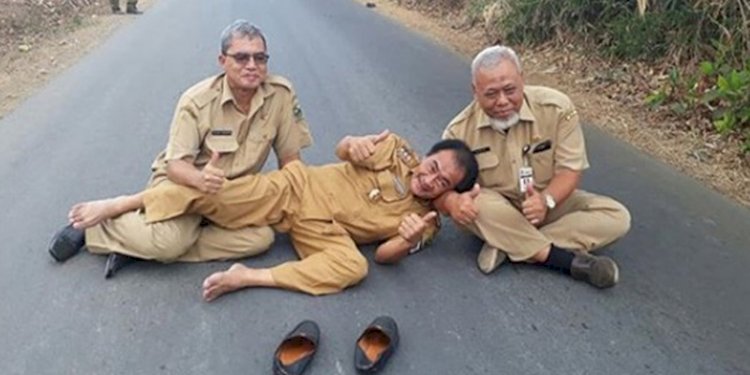 Bupati Banjarnegara,Budhi Sarwono (tengah) pose tiduran di tengah jalan di Desa Petir Kecamatan Purwanegara, Banjarnegara, Jawa Tengah/RMOLJateng 