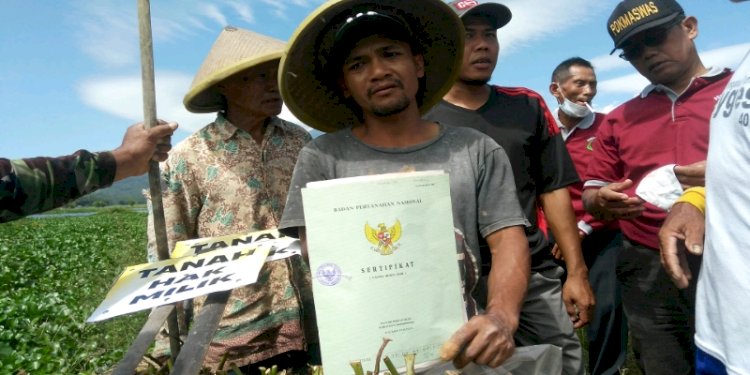 Petani saat memasang papan Hak Milik sambil menunjukkan sertifikat kepemilikan tanah di Sukodono, Desa Kebumen, Kecamatan Banyubiru, Kabupaten Semarang, Kamis (12/8). / RMOL Jateng 