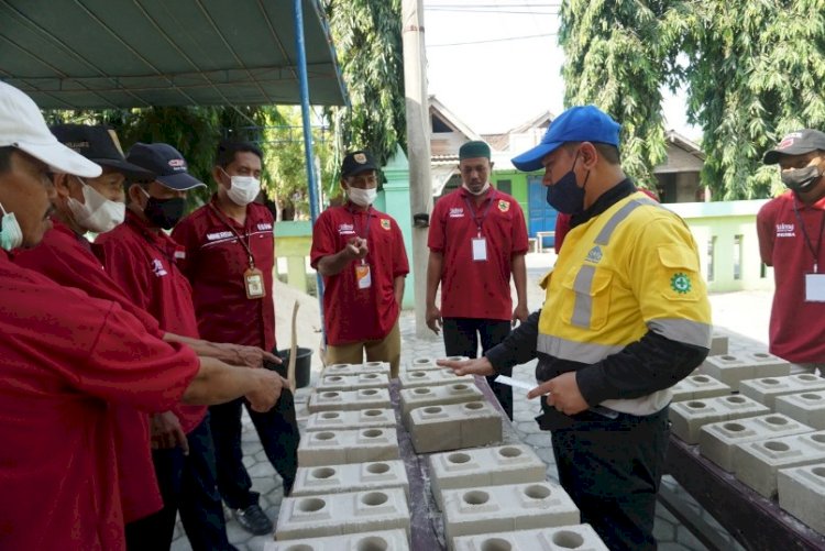 Narasumber dari Semen Gresik menilai hasil pencetakan Bata Interlock yang telah dibuat oleh peserta pelatihan./ dok. PTSG