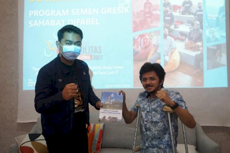 Perwakilan Semen Gresik menyerahkan Buku Merajut Harapan Menuju Keberlanjutan yang disusun oleh Semen Gresik kepada Narasumber Acara Peringatan Hari Disabilitas Internasional Semen Gresik 2021 Anjas Pramono Sukamto. Foto: PTSG