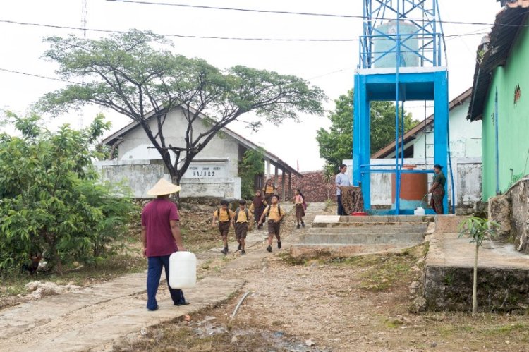 Warga Dusun Wuni, di Desa Kajar, Kecamatan Gunem, Kabupaten Rembang,  mengambil air di tandon air bantuan dari Semen Gresik. Sejak adanya program pembangunan sumber air oleh Semen Gresik, warga tidak perlu berjalan jauh untuk mengambil air bersih. foto: PTSG 