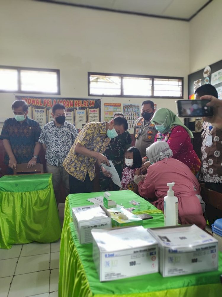 Wali Kota Salatiga Yuliyanto saat mengalihkan perhatian seorang siswa ketika mengikuti Vaksinasi Merdeka tingkat Sekolah Dasar di SD Cebongan 03 Salatiga, Kamis (13/1).