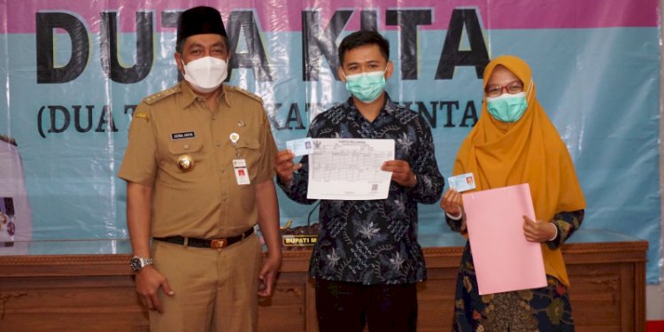 Bupati Magelang Zaenal Arifin saat menyerahkan KTP dan KK baru bagi pasangan pengantin. RMOL Jateng 