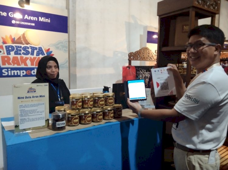 Regional CEO BRI Kanwil Semarang  Handaru Sakti melakukan pembayaran QRIS melalui BRImo di salah satu stand UMKM di ajang Pesta Rakyat Simpedes (PRS), Jumat (19/8).