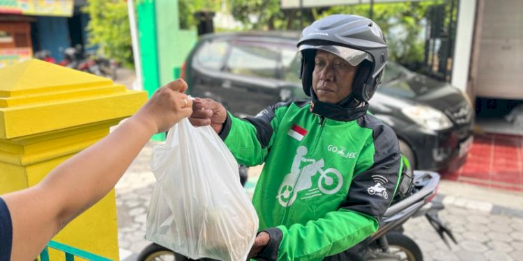 Seorang driver Gojek sedang mengantarkan pesanan ke pelanggan. RMOL Jateng