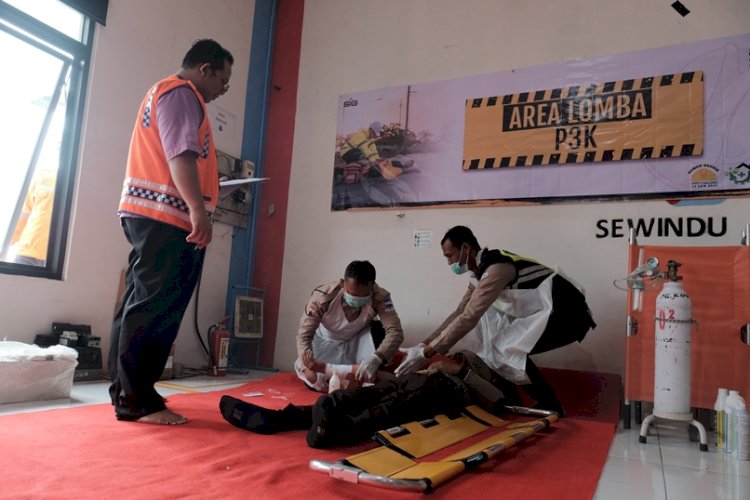 Potret pelaksanaan lomba safety challenge kategori Pertolongan Pertama Pada Kecelakaan (P3K) dalam rangkaian bulan K3 di halaman area workshop unit pemeliharaan. 