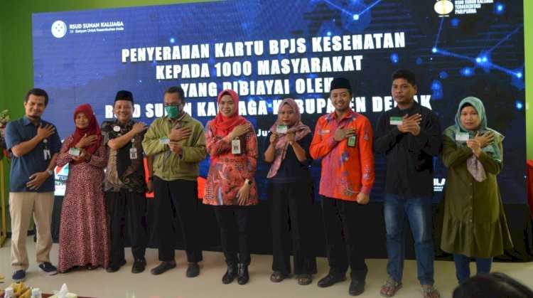 Bupati Demak Hj Eisti’anah (batik merah-tengah), Direktur RSUD Sunan Kalijaga Kabupaten Demak, dr Nugroho Aris Kusuma (batik merah peci-ketiga dari kanan) dan Kepala BPJS Kesehatan Kabupaten Demak  Slamet Widodo (paling kiri) berfoto bersama para wakil penerima bantuan Program Pendaftaran dan Pembiayaan Masyarakat secara kolektif dalam Program JKN dari RSUD Sunan Kalijaga Demak. foto-foto: dok. RMOL Jateng/Stefy Thenu.