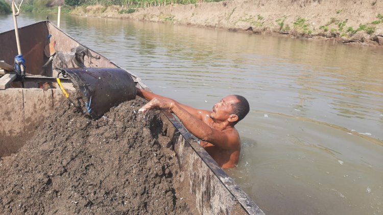 Warga mengambil pasir dari dasar sungai dikumpulkan di atas perahu 