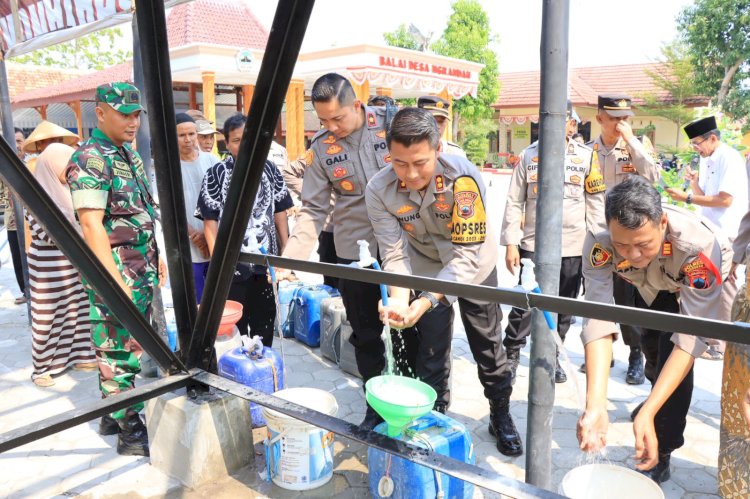 Kapolres Grobogan membuka keran air bantuan sumur bor di Ngrandah Grobogan. 