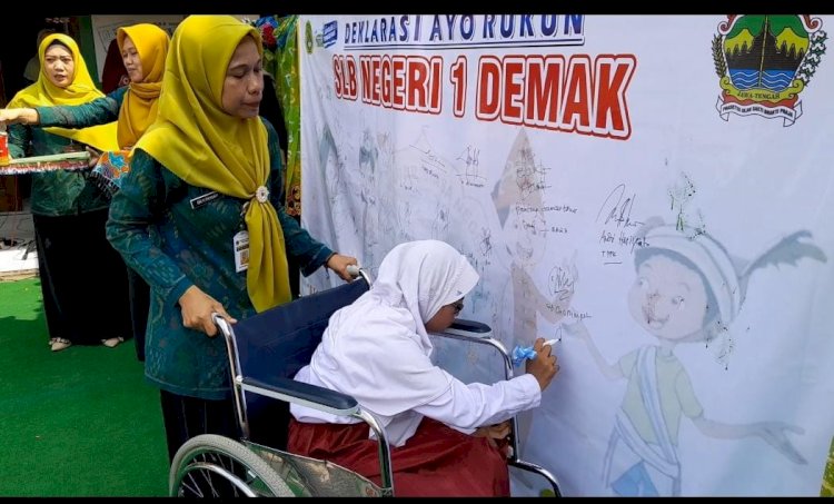 Siswa - Siswi SLB Negeri 1 dibantu guru mencantumkan tanda tangan atau cap tangan dukungan untuk stop bullying di SLB Negeri 1 Demak, Selasa (14/11)
