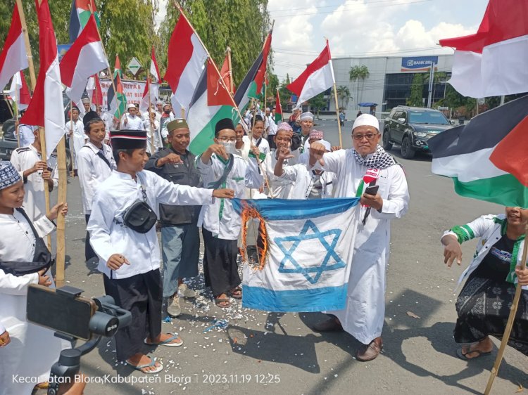 Massa membakar bendera Israel sebagai bentuk protes atas kekejaman Israel terhadap Palestina 