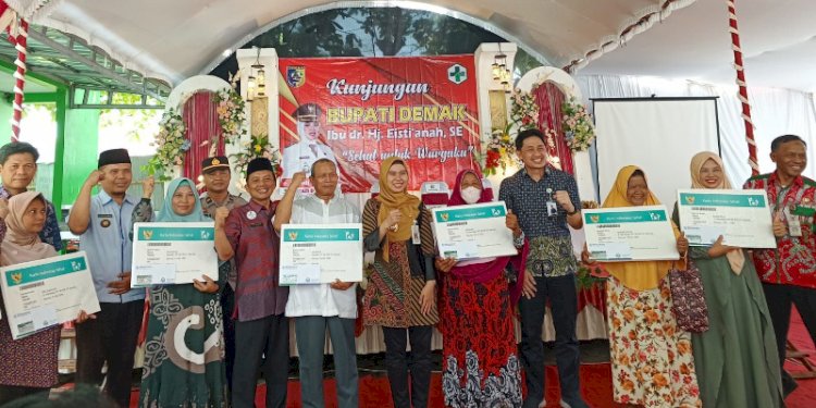 Bupati besama Forkopimcam dan Kepala BPJS Kesehatan berposes bersama para penerima sasaran PMT.