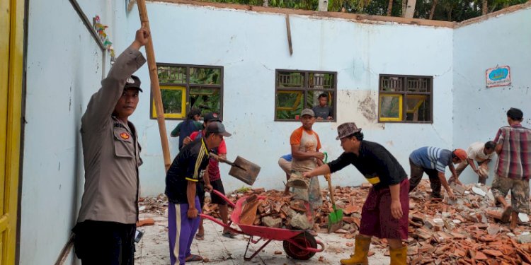 Puing puing sisa ambruknya bangunan dibersihkan oleh petugas. 