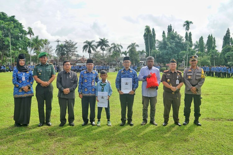 Sekda Adi Waryanto menyerahkan sejumlah bantuan kepada siswa SD/MI berprestasi, perwakilan anggota Korpri dan paket sembako.
