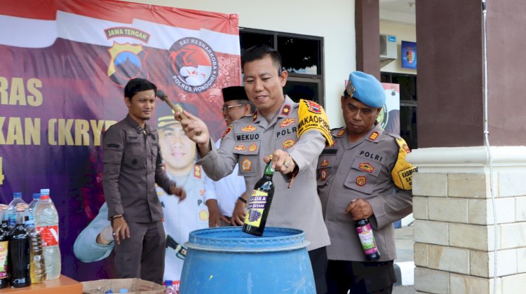 Wakapolres Wonogiri Kompol Andi Mohammad Akbar Mekuo memusnahkan satu dari ratusan miras hasil razia, Kamis (21/12/2023). Foto : Tulus Premana