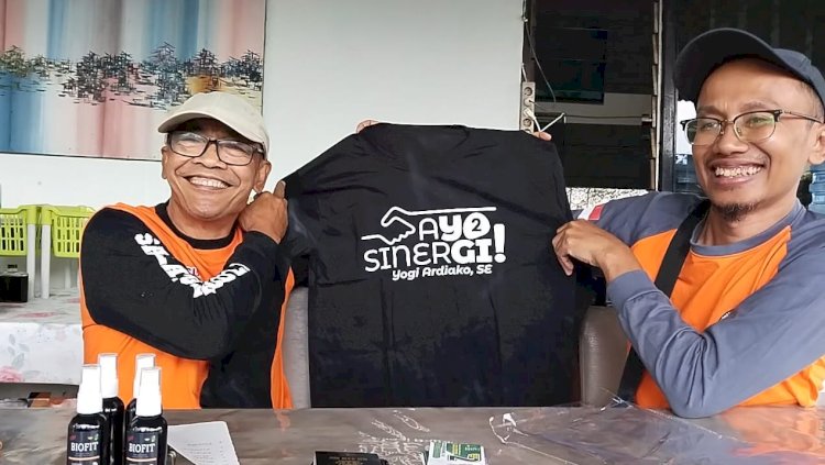 Caleg PKB Salatiga Yogi Ardiako saat menyerahkan satu kaos dengan gambar bergandengan tangan sebagai simbol Sinergitas kepada pengiat sosial gaek, Ahmad Budiharjo (71)