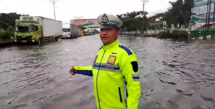 Petugas kepolisian menunjukan kondisi jalan raya saat Kota Semarang  dilanda banjir, beberapa waktu lalu. Dicky Aditya/RMOLJateng