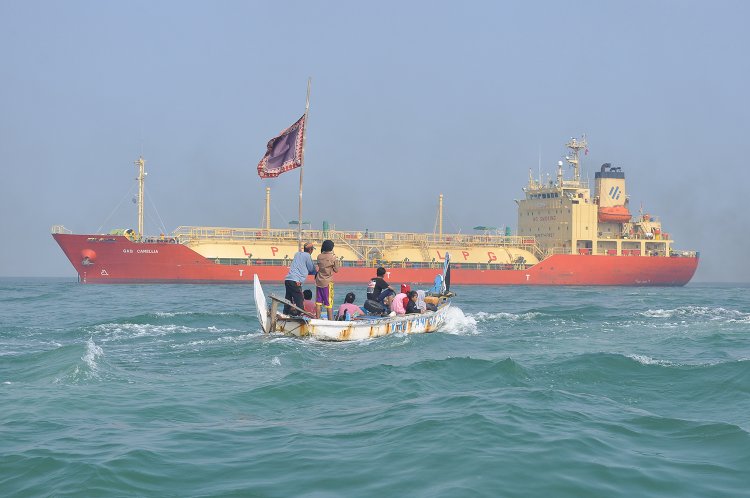 Sebuah Perahu Berisikan Nelayan Melintasi Kapal Tanker Gas Camellia Di Perairan Laut Utara Pelabuhan Tanjung Emas, Semarang, Jumat (14/06).