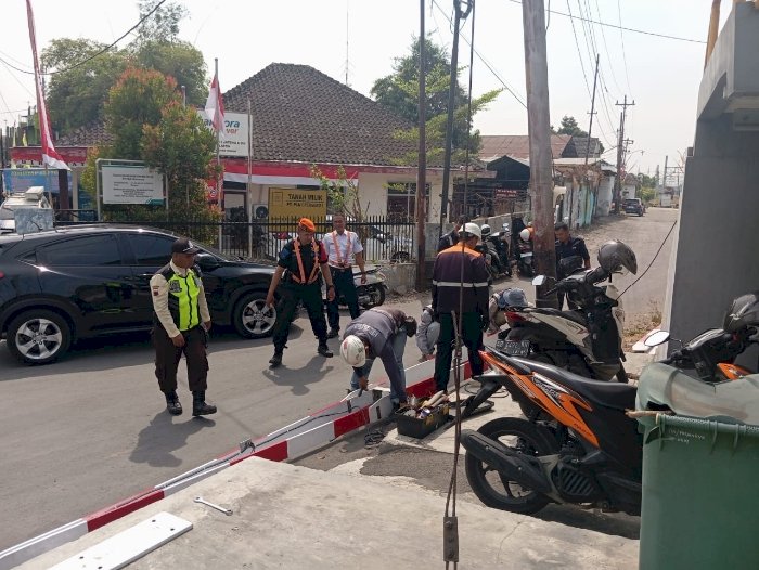 Petugas Memperbaiki Palang Kereta