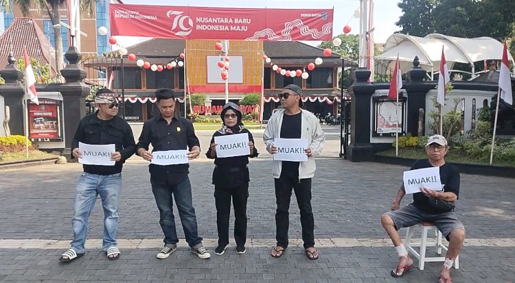 Sejumlah orang berpakaian hitam-hitam menggelar unjuk rasa membawa kertas dengan kata 'Muak' di depan Gedung DPRD Salatiga, Kamis (22/8). Erna Yunus B/RMOLJateng