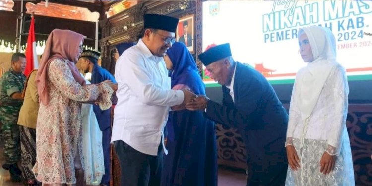 PJ Bupati Kudus Hasan Chabibie menyalami pasangan nikah massal dalam rangkaian Hari Jadi Kabupaten Kudus ke 475 diikuti enam pasangan pengantin, di Pendopo Kabupaten Kudus.