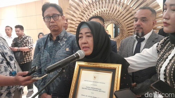 Momen Pemberian Anugerah Satria Bakti Husada Arutala Diserahkan Langsung Oleh Menteri Budi Gunadi Sadikin, Menteri Kesehatan (Menkes) Kepada Ibundanya, Nuzmatun Malinah, Di Jakarta, Kamis (09/01). Dokumentasi detik.com