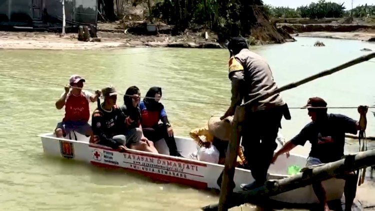 Relawan bersama TNI Polri membantu seberangkan warga Baturagung Gubug Grobogan untuk beraktifitas, Kamis (13/3) siang. 